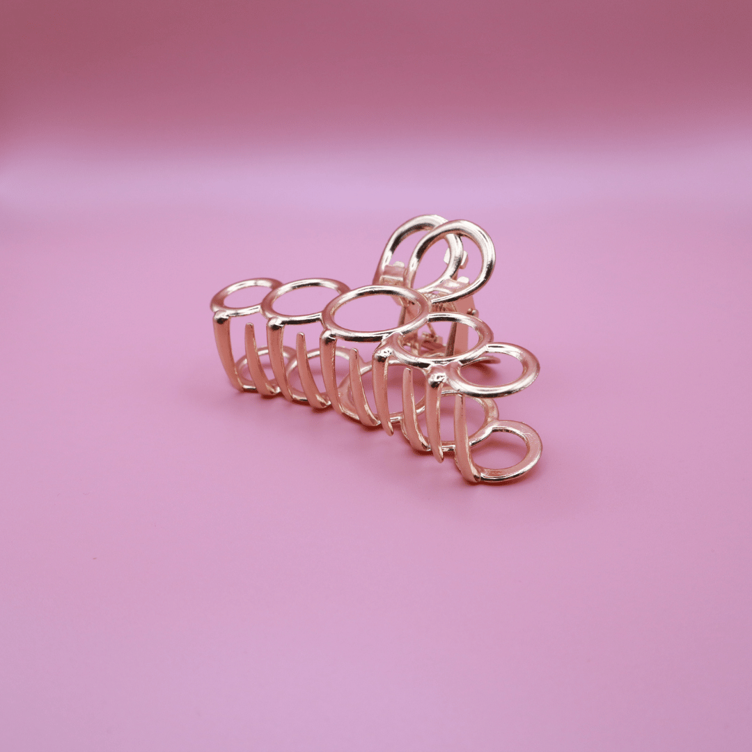 Golden Belle signature gold claw hair clip set with elegant minimalist design and strong metal grip on pink background
