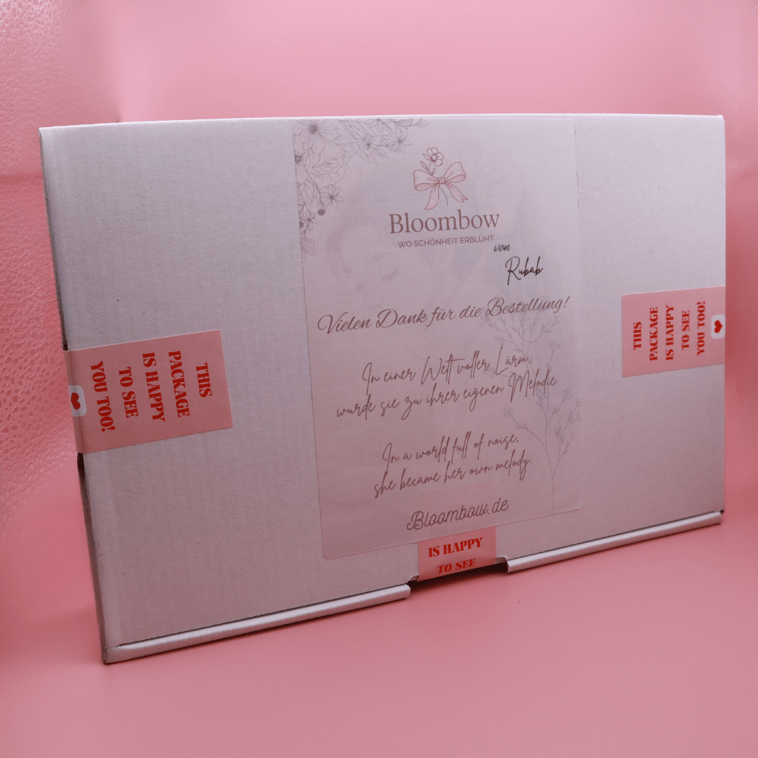 White rectangular box packaging of Golden Belle Signature Claw Clip Set by Bloombow with red tape and a thank you note on pink background