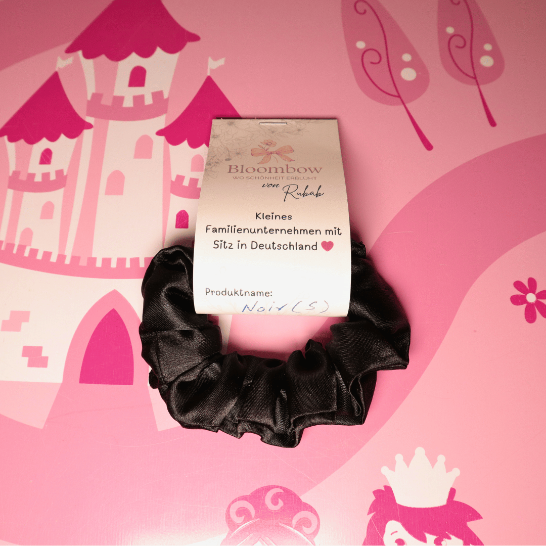 Schwarzer Satin-Scrunchie von Bloombow, handgefertigt in Deutschland, umweltfreundlich verpackt.