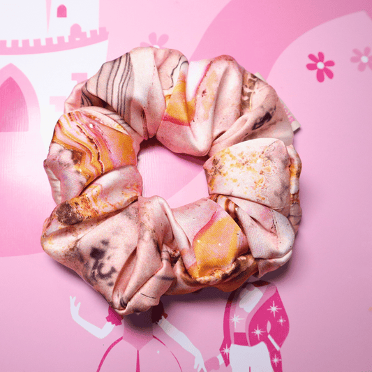 Pearl-themed floral scrunchie on pink background, handcrafted and eco-friendly.