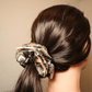 Scrunchie in Salbeifarben mit Paisley-Muster im Haar, haarschonend und stilvoll.