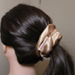 Golden satin scrunchie holding ponytail, Daisy design.