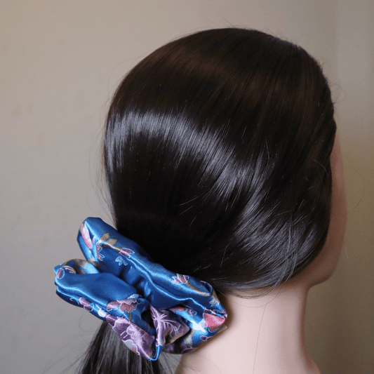 Blue floral satin scrunchie in dark hair.