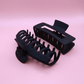 Set of black matte plastic hair claw clips on a pink background, Haarklammern Set