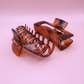 PastelPetal Haarklammer Set in transparent brown with strong hold and matte finish on pink background