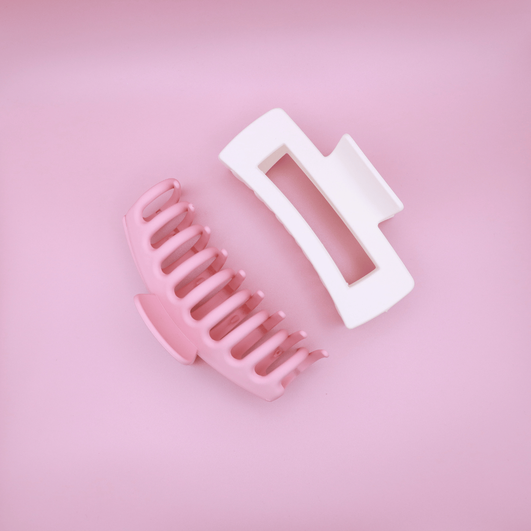 Pastel-colored Haarklammern set with pink and white clips on pink background, stylish and gentle on hair.
