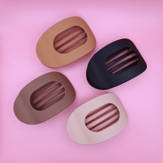Set of four neutral matte hair claw clips in beige, light brown, dark brown, and matte black on pink background, minimalist Haarklammer-Set for strong hold and elegant style.