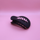 Black matte haarklammer clip with ergonomic design on pink background, part of Classic Calm Haarklammer-Set