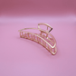 Golden Belle signature gold metal claw hair clip with sturdy grip on pink background