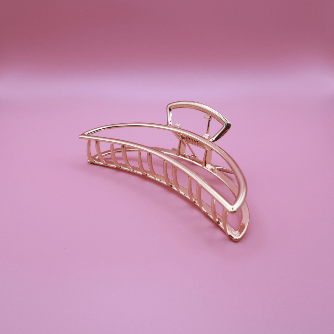 Golden Belle signature gold metal claw hair clip with sturdy grip on pink background