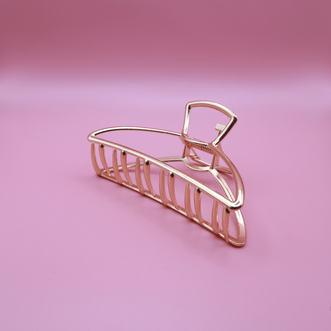 Golden metal claw hair clip from Golden Belle signature set on pink background